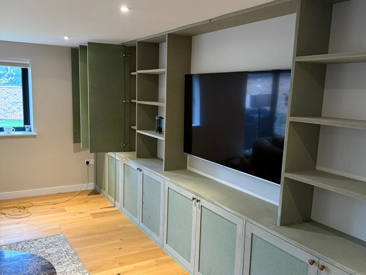 Built-in media wall and open shelving in bare MDF before spraying