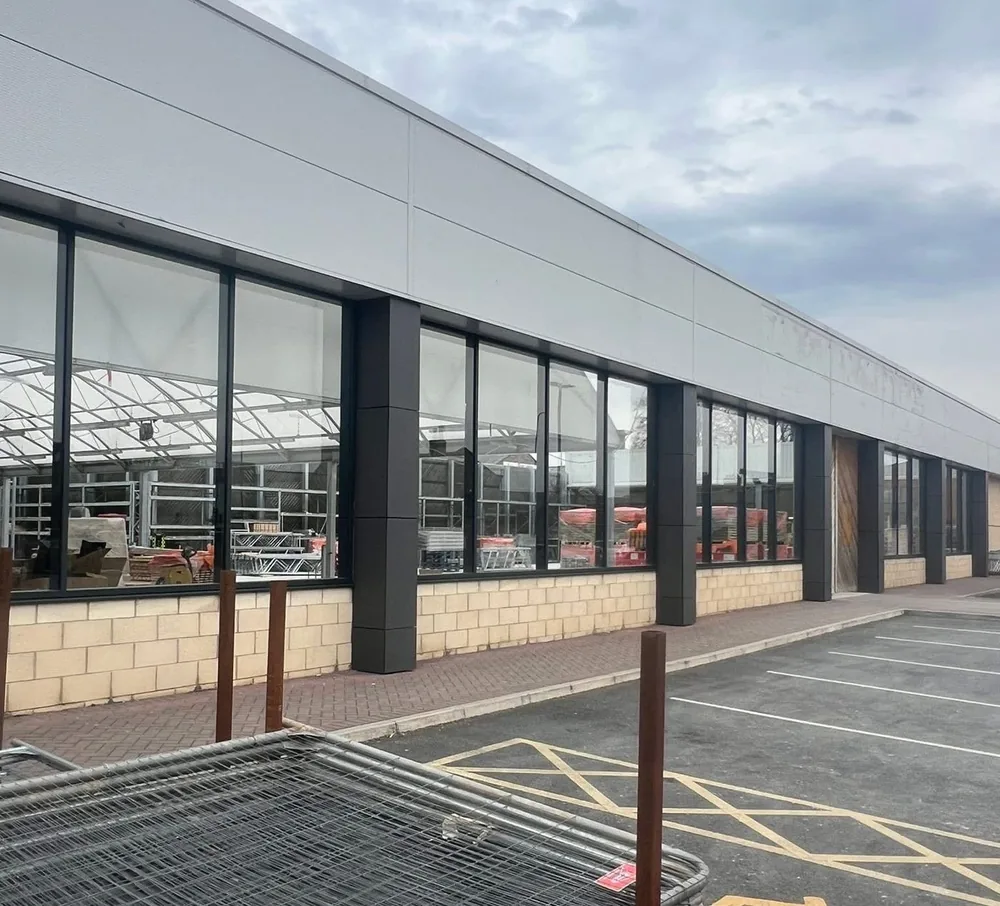 Long retail elevation with window frames and columns sprayed dark grey