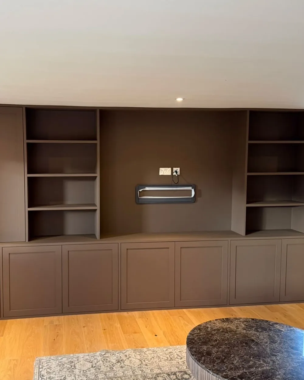 Fitted media wall with open shelving sprayed in a deep taupe