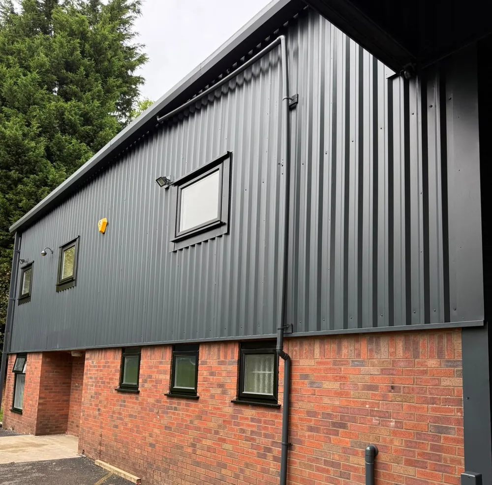 Industrial unit cladding and window surrounds sprayed dark anthracite above red brick